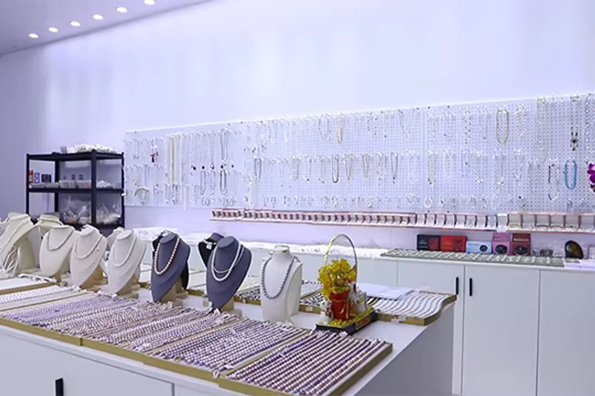 Pearl necklaces displayed on stands and wall racks in a bright showroom
