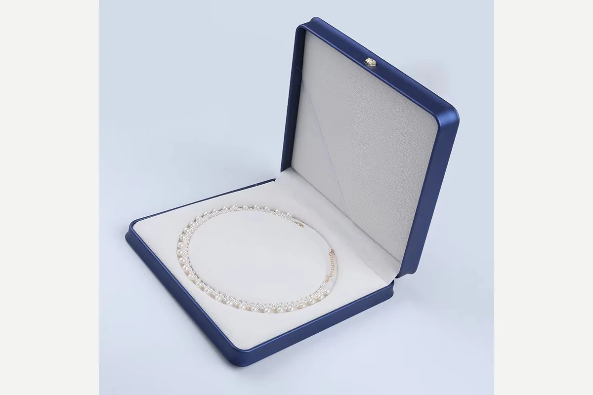White pearl necklace inside an open blue jewelry box