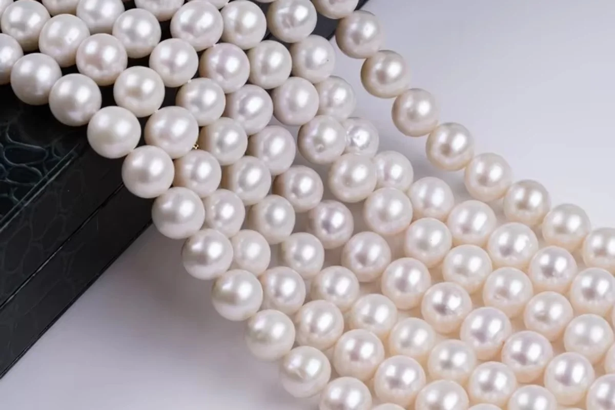 White pearl strands draped over a black display box