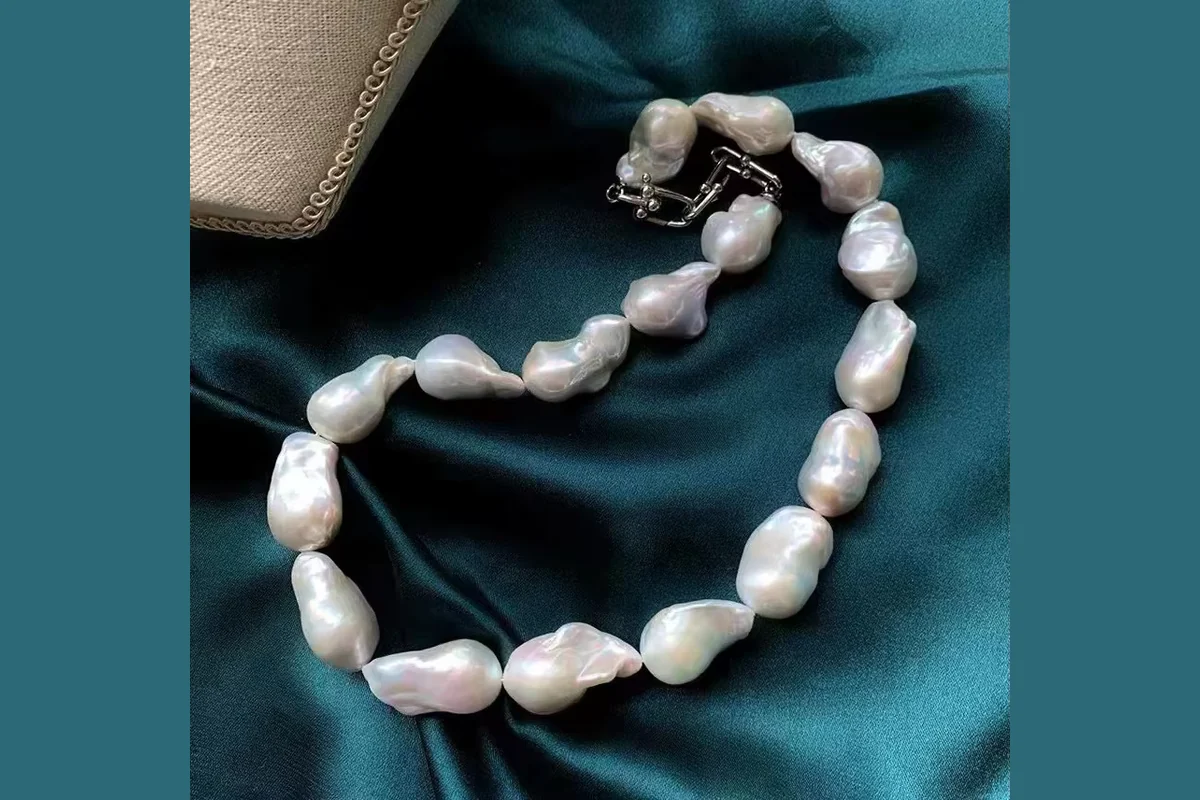 A necklace of irregular white pearls with its clasp visible.
