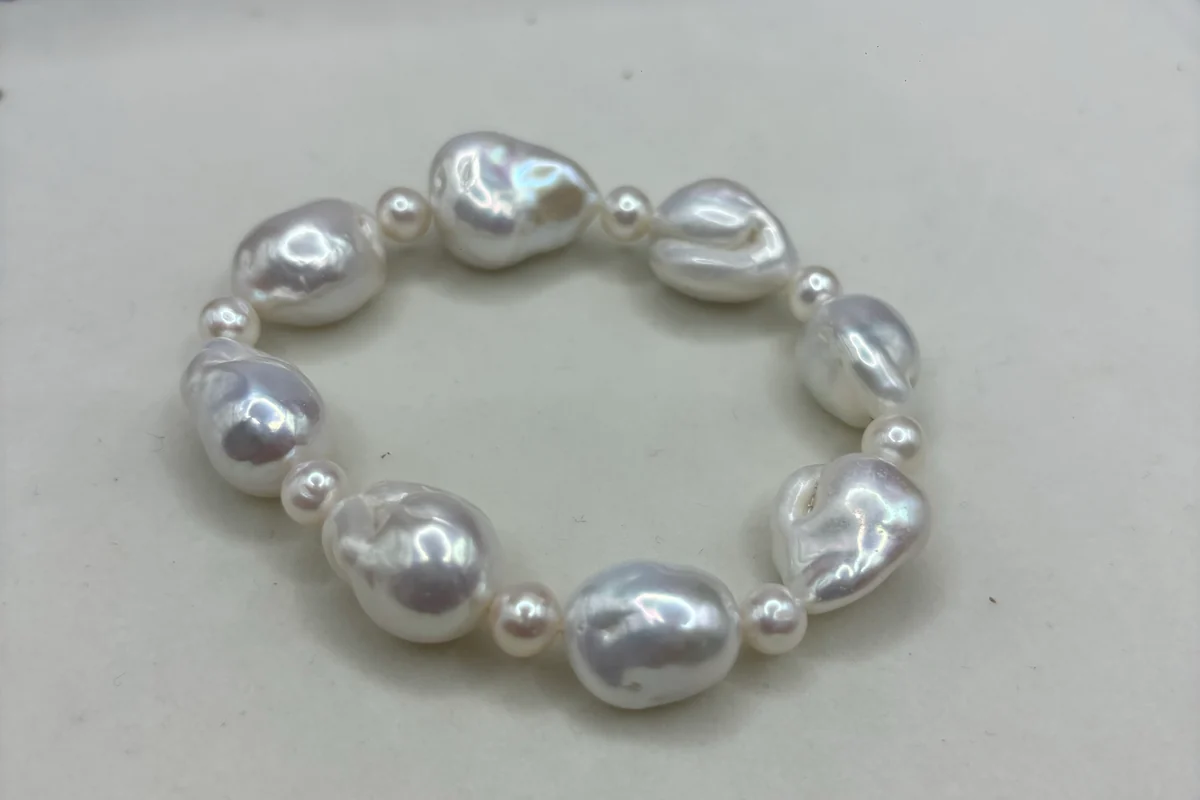 A bracelet of large white baroque pearls separated by small pearls.