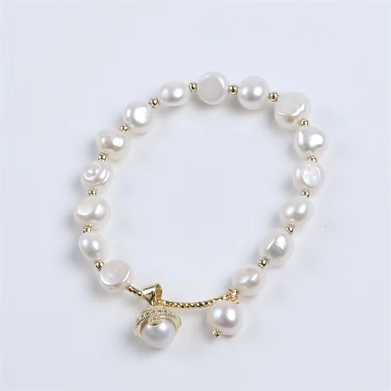 A white pearl bracelet with two hanging pearl charms.