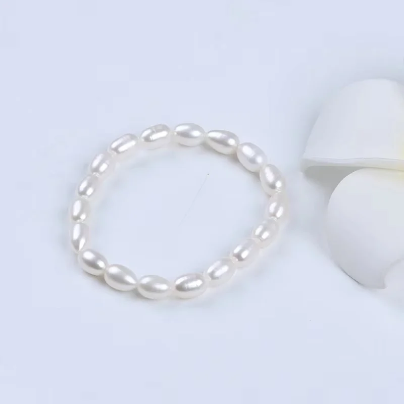 A white rice pearl stretch bracelet on a pale background.