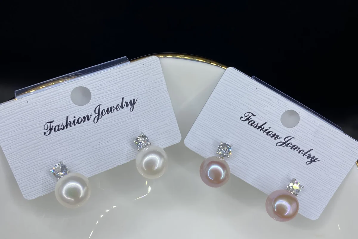 White and lavender pearl earrings on display cards.
