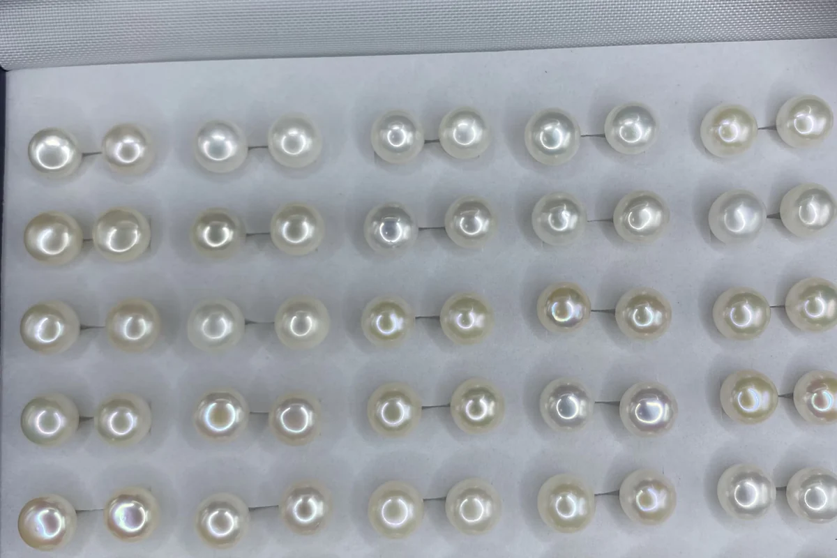 Rows of white pearl stud pairs in a display tray.