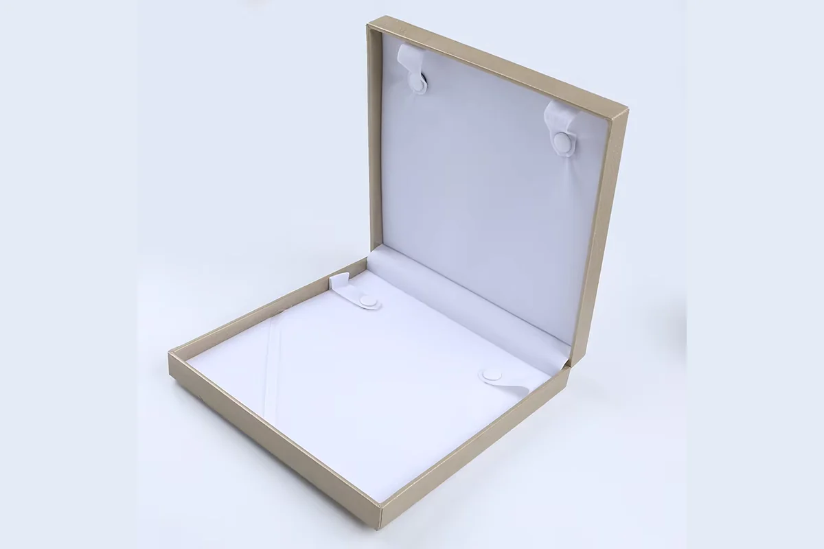Open cream jewelry box with a white necklace insert