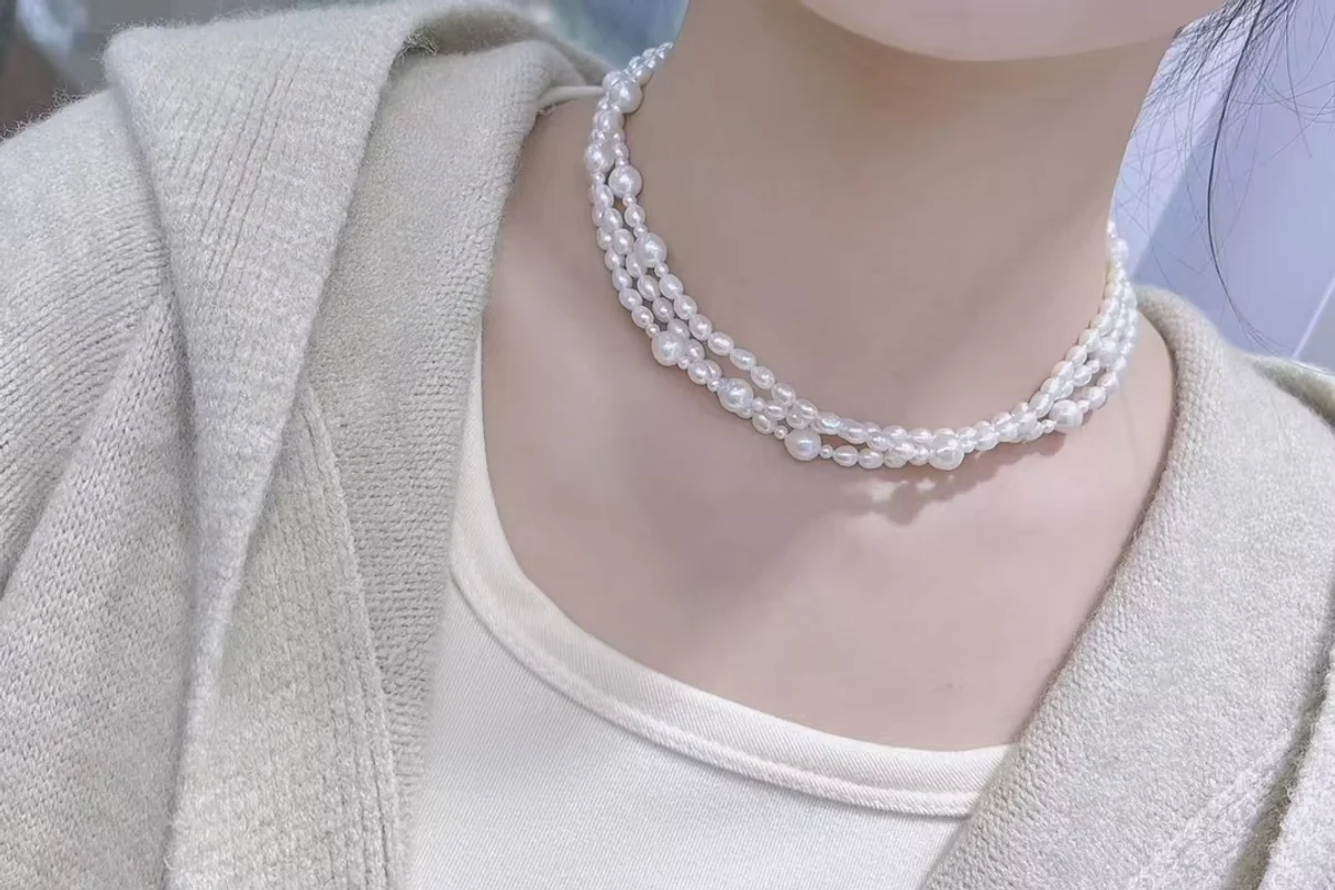 Several white pearl strands layered around the neck