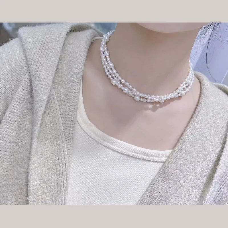 Layered white pearl strands worn close to the neck