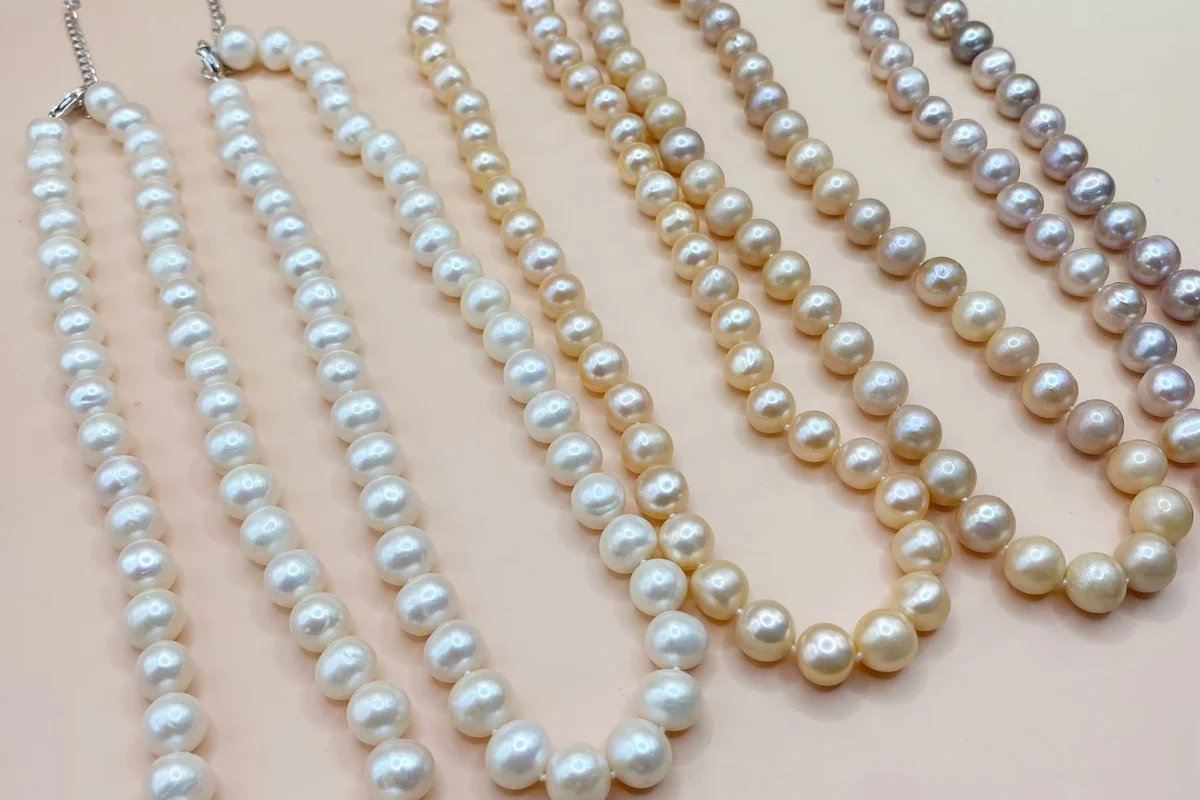 White, peach and lavender pearl necklaces with extension chains.