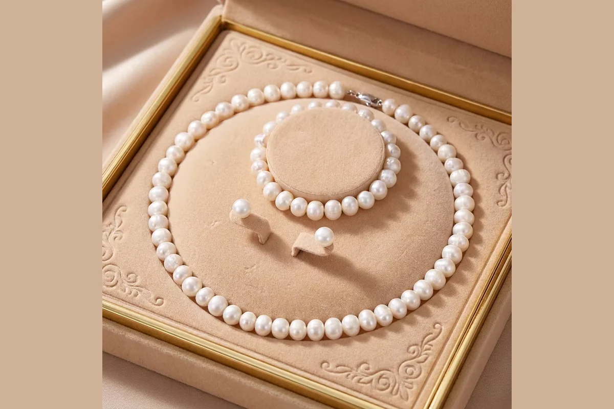 White pearl necklace, bracelet and stud earrings in a tan presentation box