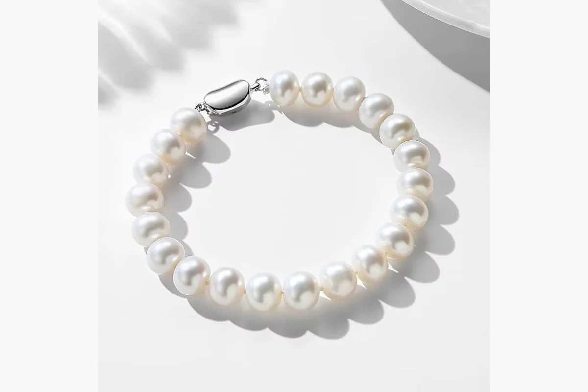 White pearl strand bracelet with a clasp on a light surface