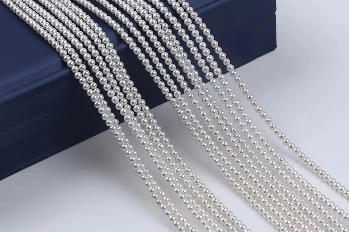Several small white pearl strands draped over a blue display box